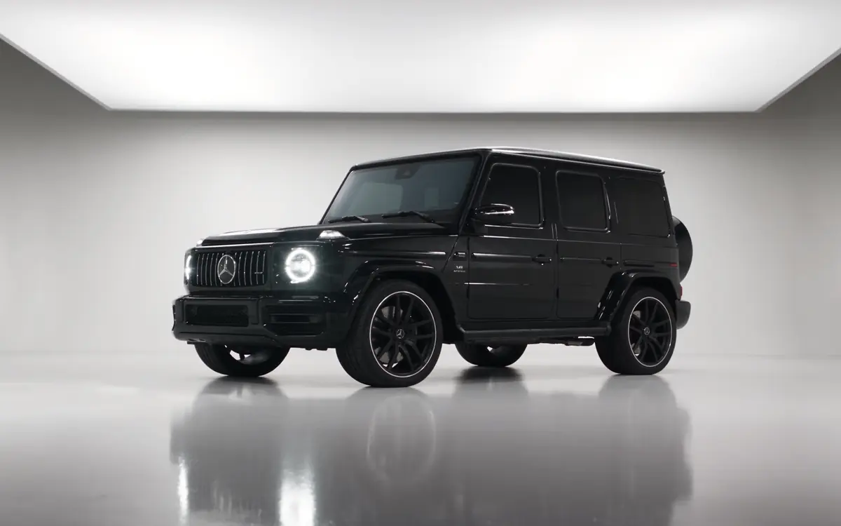A black Mercedes-AMG G 63 in a white photo studio (illustrative, generated).